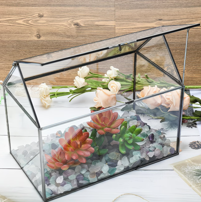 Glazen terrarium gevuld met vetplanten en decoratie