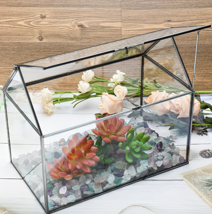 Glazen terrarium gevuld met vetplanten en decoratie